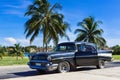 American black Chevrolet classic car parked under palms near the beach in Varadero Cuba - Serie Cuba Reportage Royalty Free Stock Photo