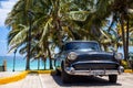 American black classic car parked under palms Royalty Free Stock Photo