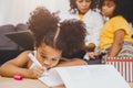 American Black preschool daughter kids doing homework learning education with her sister living together at home