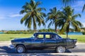 American black vintage car parked under palms near the beach in Varadero Cuba - Serie Cuba Reportage Royalty Free Stock Photo
