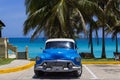 American blue Buick Eight classic car parked under palms on the beach in Varadero Cuba -Serie Cuba Reportage Royalty Free Stock Photo