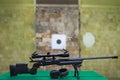 American bolt action sniper rifle in a shooting range, with active headphones for shooting on the table Royalty Free Stock Photo