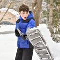 Boy With Blue and Black Snowsuit Shoveling