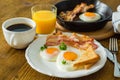 American breakfast with sunny side up eggs, bacon, toast, pancakes, coffee and juice Royalty Free Stock Photo