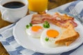 American breakfast with sunny side up eggs, bacon, toast, pancakes, coffee and juice Royalty Free Stock Photo