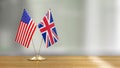 American and British flag pair on a desk over defocused background