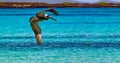 American brown pelican flies over turquoise water near Cerro Brujo beach Royalty Free Stock Photo