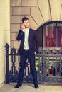 Young man standing outside office building in New York City, talking on cell phone Royalty Free Stock Photo