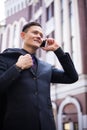 American businessman talking on a smartphone on an autumn city street. Smiling against the background of the bank building Royalty Free Stock Photo