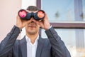 American businessman using binoculars in office. Spy of competitors Royalty Free Stock Photo