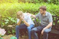 American businessmen consoling friend. Frustrated young man being consoled by his friend in garden. Royalty Free Stock Photo