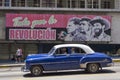 American cars under a cuban propaganda billboard Royalty Free Stock Photo