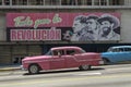 American cars under a cuban propaganda billboard Royalty Free Stock Photo