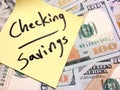 American cash money and yellow sticky note with text Checking and savings