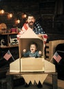 American cheerful family with usa flags play with rocket made out of cardboard box. Rocket launch concept. Kid happy sit