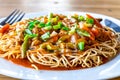 American Chopsuey served in a white plate on wooden surface