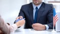 American consular officer giving passport to female immigrant, refugee visa Royalty Free Stock Photo