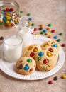 American cookies with colorful chocolate candy drops served with glass of milk.