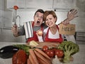 American couple in stress at home kitchen in cooking apron asking for help frustrated Royalty Free Stock Photo