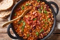 American cowboy beans with ground beef, bacon in a spicy sauce close-up. horizontal top view Royalty Free Stock Photo