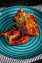 American cuisine. Grilled marinated pork ribs on a blue plate with shrimp and spicy chili in barbecue sauce. Background image. Royalty Free Stock Photo