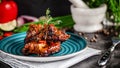American cuisine. Grilled marinated pork ribs on a blue plate with shrimp and spicy chili in barbecue sauce. Background image. Royalty Free Stock Photo