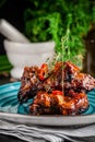 American cuisine. Grilled marinated pork ribs on a blue plate with shrimp and spicy chili in barbecue sauce. Background image. Royalty Free Stock Photo