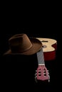 American culture, folk song and country muisc concept theme with a cowboy hat and an acoustic guitar isolated on black background