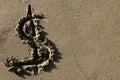 American currency dollar sign on the beach sand