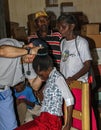 American doctor examines sick young girl in clinic with family.