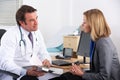 American doctor talking to businesswoman patient