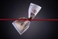 American dollar tied up in red rope knot on dark background with copy space. business finances, savings and bankruptcy concept Royalty Free Stock Photo