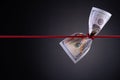 American dollar tied up in red rope knot on dark background with copy space. business finances, savings and bankruptcy concept Royalty Free Stock Photo