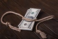 American dollar tied up in rope knot on dark background with copy space. business finances, savings and bankruptcy concept Royalty Free Stock Photo