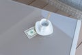 American dollars bill and empty cup of coffee on a glass table of outdoor cafe. Payment, tip Royalty Free Stock Photo