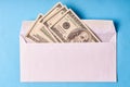 American dollars in a white envelope. Blue background