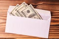 American dollars in a white envelope. Wooden background Royalty Free Stock Photo