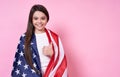 The American Dream. July 4, USA. beautiful girl in a white T-shirt with the American flag, on a pink background