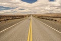 American empty desert asphalt road from low angle with mountains and clouds on background. El Calafate to Puerto Natales.