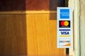 American Express, MasterCard, VISA, Discover payment options advertised on a restaurant door