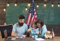 American family at desk with son making paper planes. Homeschooling concept. Parents teaching son to create, handmade Royalty Free Stock Photo