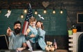 American family at desk with son making paper planes. Homeschooling concept. Parents teaching son american traditions Royalty Free Stock Photo