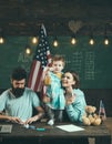 American family at desk with son making paper planes. Parents teaching son american traditions playing. Kid with parents Royalty Free Stock Photo