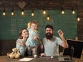 American family at desk with son play with paper planes. Kid with parents in classroom with usa flag, chalkboard on Royalty Free Stock Photo