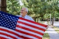 American federal holiday of senior man holds the flag of America in his hands Independence day