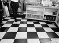 American Fifties Diner - Waitress Walking on Black and White Checkerboard Floor Royalty Free Stock Photo