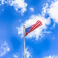 American flag against a blue sky with white clouds Royalty Free Stock Photo
