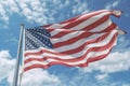 American flag against a blue sky backdrop. consists of 13 horizontal stripes, seven red and six white, and a blue rectan Royalty Free Stock Photo