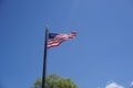 American Flag against blue sky, flapping