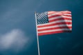 American flag, on against a overcast sky.